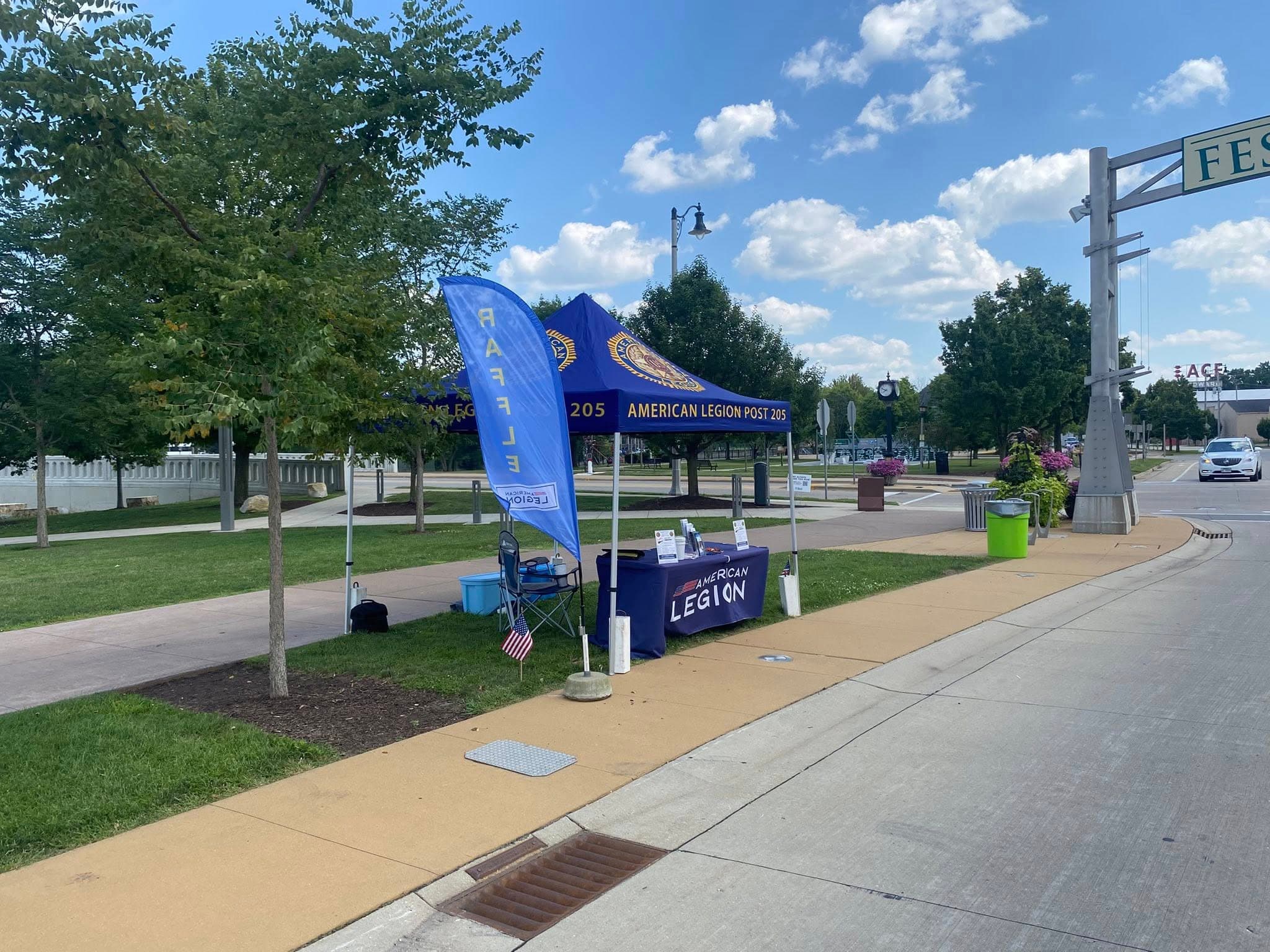 Post 205 booth with American Legion banner and feather flag